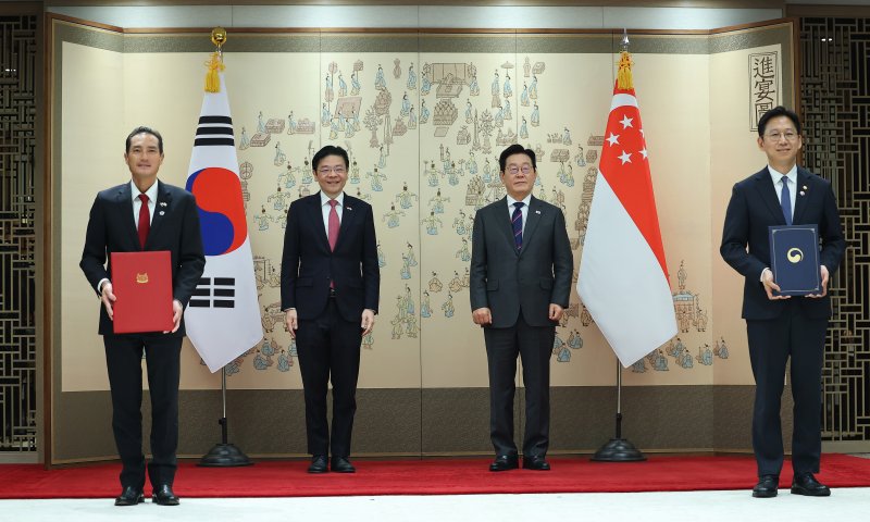 [서울=뉴시스] 고범준 기자 = 배경훈 과학기술정보통신부 장관과 탄 키앗 하우 싱가포르 보건·디지털개발정보 선임국무장관이 2일 서울 용산 대통령실 청사에서 이재명 대통령과 로렌스 웡 싱가포르 총리가 참석한 가운데 '디지털 협력에 관한 양해각서'를 교환하고 기념촬을 하고 있다. (대통령실통신사진기자단) 2025.11.02. bjko@newsis.com