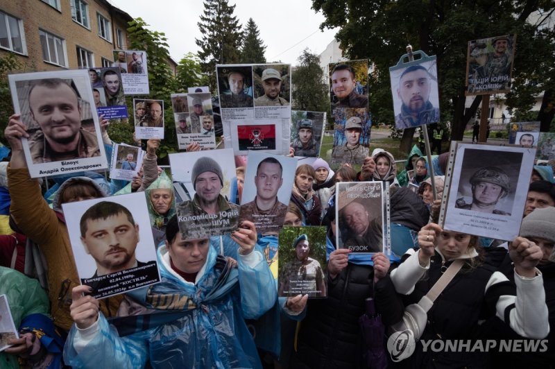 전쟁포로 사진 들고 있는 우크라이나 시민들 (출처=연합뉴스)