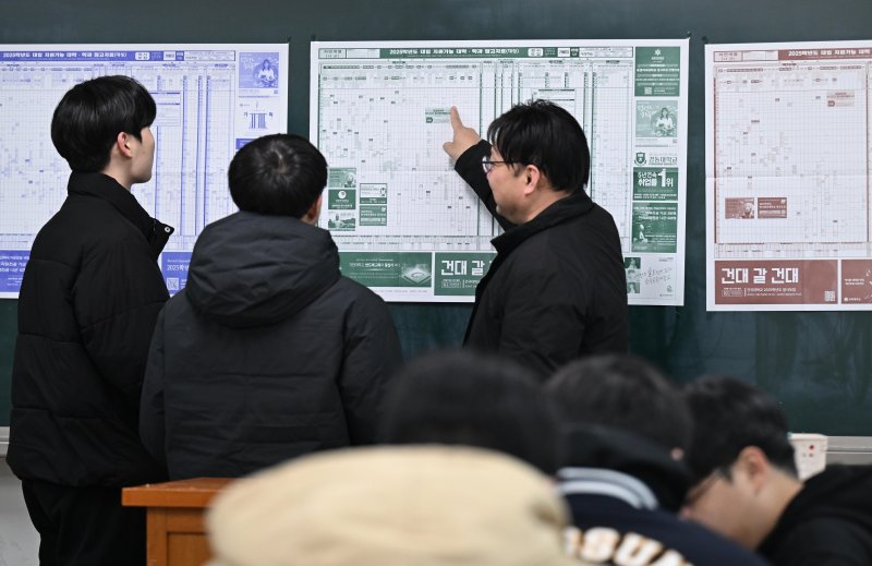 [서울=뉴시스] 사진공동취재단 = 2025학년도 대학수학능력시험(수능) 성적표가 배부된 6일 서울 종로구 동성고등학교에서 고3 담임 선생님이 수험생들과 지원 가능 대학 배치표를 살펴보고 있다. 2024.12.06. photo@newsis.com