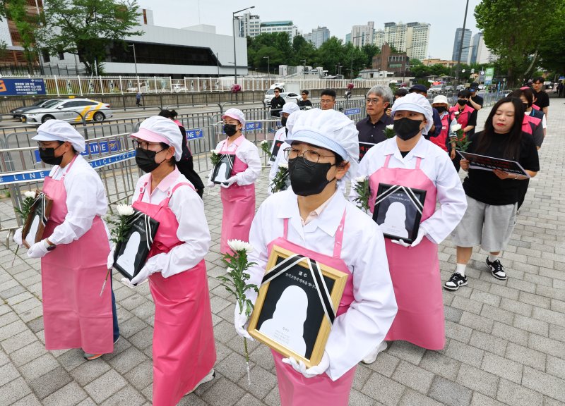 [서울=뉴시스] 황준선 기자 = 24일 오전 서울 용산구 대통령실 앞에서 열린 죽음의 학교 급식실 폐암 산재 문제 해결을 위한 학교급식법 개정 촉구 기자회견에서 참석자들이 대통령실에 요구안을 전달하기 위해 행진하고 있다. 2025.06.24. hwang@newsis.com