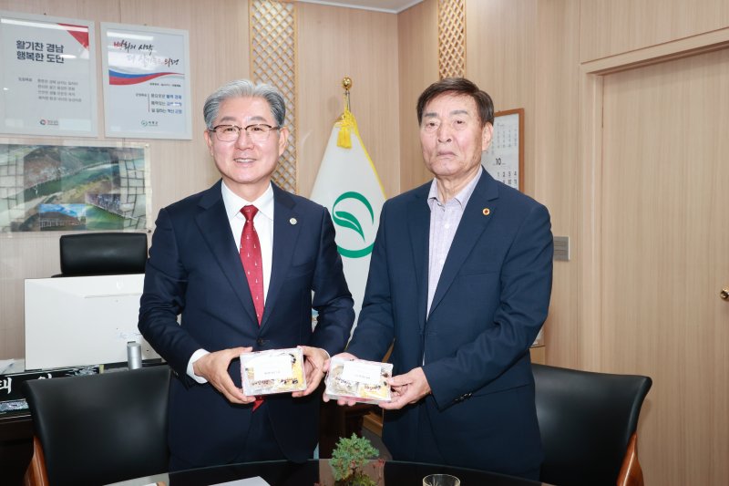 황진탁씨(오른쪽)가 지난달 30일 의령군청 군수실에서 오태완 군수에게 감사의 마음을 전한 떡을 전달하고 있다(의령군 제공. 재판매 및 DB금지).