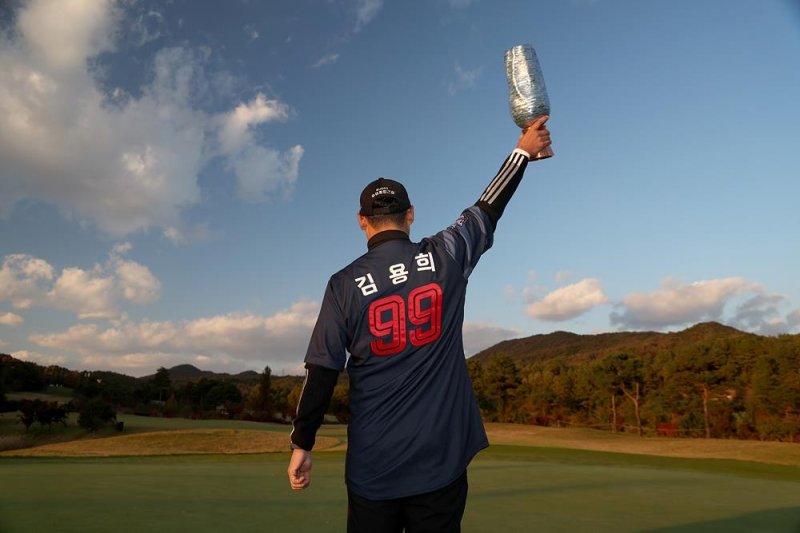 아버지 김용희 감독의 유니폼 입고 우승 트로피 드는 김재호 (출처=연합뉴스)