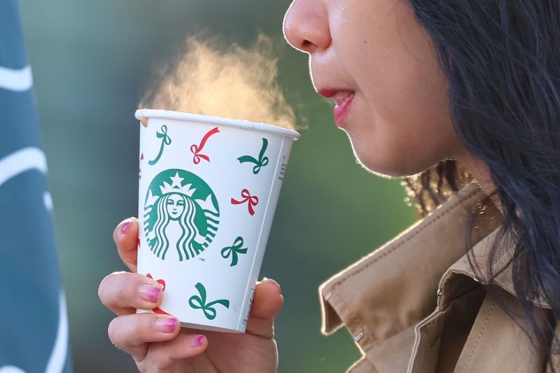 [서울=뉴시스] 권창회 기자 = 서울 아침 최저기온이 1도까지 떨어지며 첫 한파특보가 발령된 3일 오전 서울 종로구 광화문 네거리에서 직장인이 출근하며 커피를 마시고 있다. 2025.11.03. kch0523@newsis.com