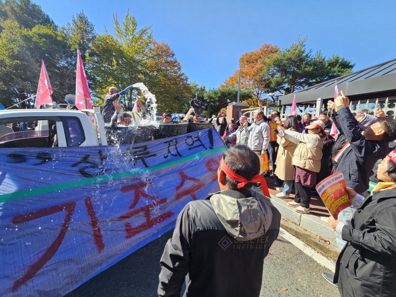 산청군 주민들이 3일 수자원공사 남강댐지사 앞에서 폭우에 물에 빠진 장면을 연출하고 있다. 2025011.3/뉴스1 한송학기자