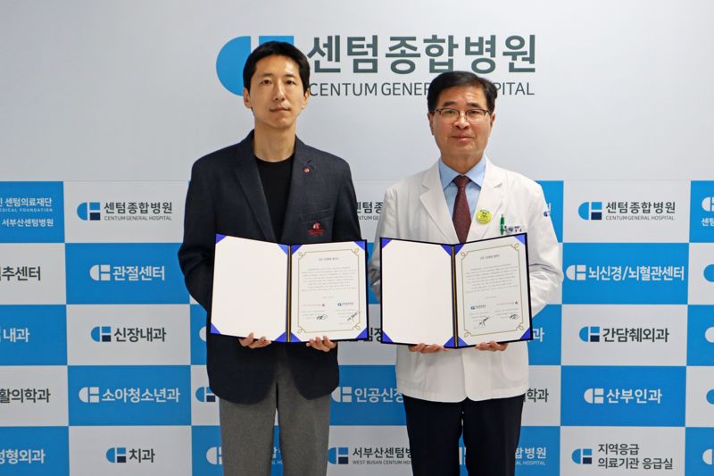 롯데월드 이경호 영남영업부문장(왼쪽)과 센텀의료재단 센텀종합병원 박종호 이사장이 업무협약서를 들고 포즈를 취하고 있다. 롯데월드 어드벤처 부산 제공