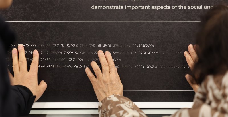 [인천=뉴시스] 전진환 기자 = 점자의 날을 하루 앞둔 3일 오후 인천 미추홀구 송암점자도서관 송암 박두식 기념관에서 시각 장애인들이 한글 점자 훈맹정음의 유래와 역사적 가치를 설명한 점자 안내문을 읽고 있다. 점자의 날은 시각장애인의 세종대왕이라 불리는 송암 박두성 선생이 시각장애인을 위해 한글 점자를 만들어 반포한 1926년 11월 4일을 기념하는 날이다. 2025.11.03. amin2@newsis.com