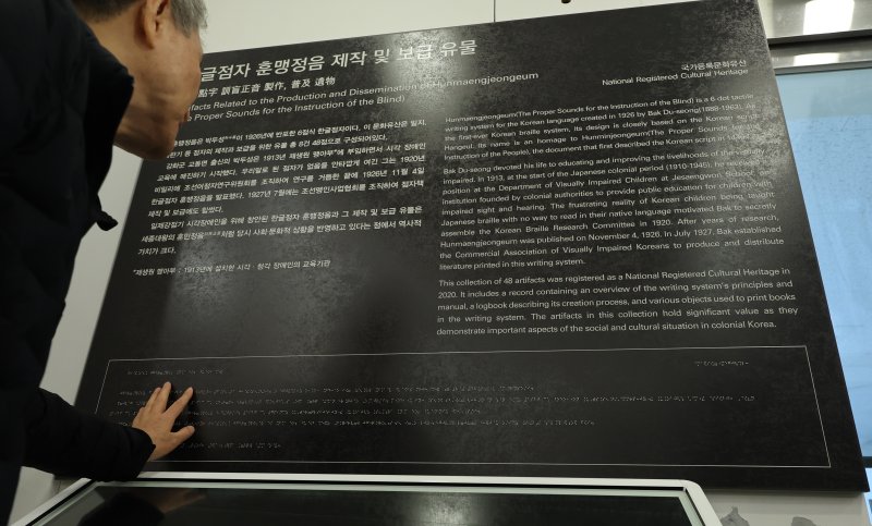 [인천=뉴시스] 전진환 기자 = 점자의 날을 하루 앞둔 3일 오후 인천 미추홀구 송암점자도서관 송암 박두식 기념관에서 시각 장애인이 한글 점자 훈맹정음의 유래와 역사적 가치를 설명한 점자 안내문을 읽고 있다. 점자의 날은 시각장애인의 세종대왕이라 불리는 송암 박두성 선생이 시각장애인을 위해 한글 점자를 만들어 반포한 1926년 11월 4일을 기념하는 날이다. 2025.11.03. amin2@newsis.com