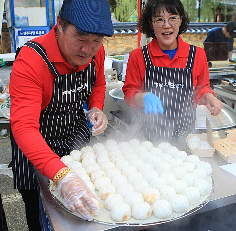 [원주=뉴시스] 이덕화 기자 = 24일 강원 원주시 대표 먹거리축제인 '원주만두축제'가 중앙동 전통시장과 문화의거리, 원일로 일원에서 열린 가운데 만두를 파는 부부의 얼굴에 웃음이 끊이지 않고 있다. 2025.10.24. wonder8768@newsis.com
