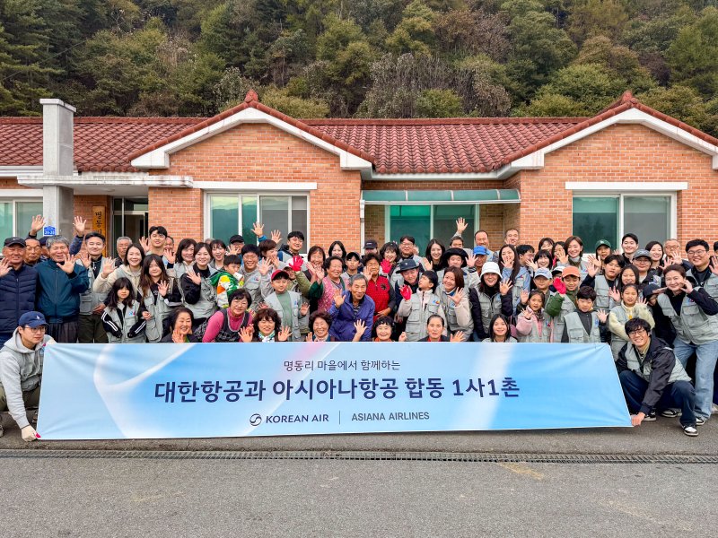 대한항공과 아시아나항공 임직원이 지난달 31일 강원 홍천군 명동리 마을에서 농가일손돕기 봉사활동을 한 뒤 기념촬영을 하고 있다. 대한항공 제공