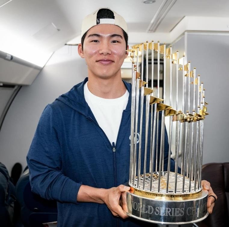 구단 전세기에서 우승 트로피 들고 포즈 취하는 김혜성 (출처=연합뉴스)