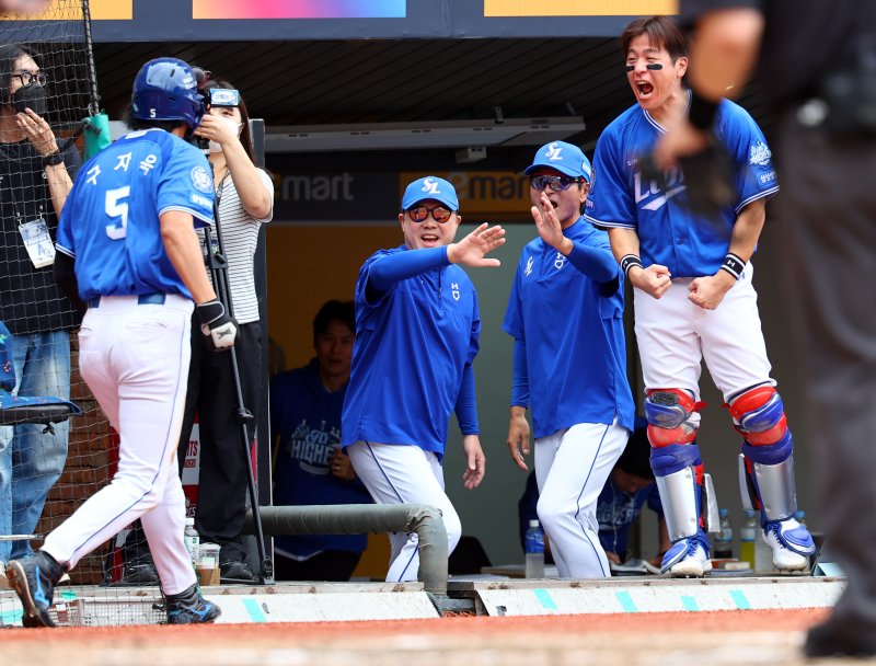 [서울=뉴시스] 박주성 기자 = 11일 인천 미추홀구 SSG랜더스필드에서 열린 2025 KBO 포스트시즌 준플레이오프 2차전 삼성 라이온즈와 SSG 랜더스의 경기, 4회초 원아웃 주자 2, 3루에서 삼성 디아즈의 2타점 적시타 때 홈을 밟은 구자욱이 박진만 감독을 비롯한 코칭스테프, 팀 동료와 기쁨을 나누고 있다. 2025.10.11. park7691@newsis.com