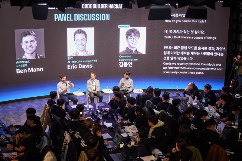 [서울=뉴시스] SK텔레콤은 SK AI 서밋 2025 부대행사로 앤트로픽 공동 개최 해커톤과 장애 청소년 행복 AI 코딩챌린지를 성료했다고 4일 밝혔다. 사진은 해커톤을 공동 개최한 SK텔레콤의 에릭 데이비스 AI 기술 협력 본부장(앞줄 가운데)과 앤트로픽의 벤자민 맨 공동창업자(앞줄 왼쪽), 콕스웨이브의 김동언 엔지니어링 리드가 해커톤 참가자들 앞에서 AI 분야에 대한 패널 토론을 진행하는 모습. (사진=SKT 제공) 2025.11.04. photo@newsis.com *재판매 및 DB 금지