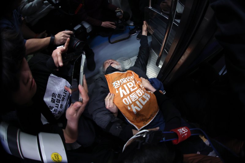 박경석 전국장애인차별철폐연대(전장연) 대표가 지난4월 21일 서울 지하철 4호선 혜화역 동대문 방면 승강장에서 제62차 '출근길 지하철 탑니다' 시위를 벌이던 중 이를 저지하던 경찰·서울교통공사 직원 등과 충돌하며 열차 입구에 넘어져 있다. 2025.4.21/뉴스1 ⓒ News1 이동해 기자