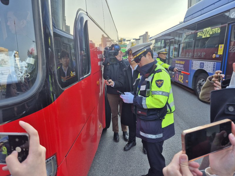 [서울=뉴시스] 이윤석 수습기자=4일 오전 서울 종로구 경복궁사거리 인근. 경찰이 꼬리물기한 버스를 단속해 흰색 빗금 안전지대에 세워 범칙금을 부과하고 있다. 2025.11.04. leeys@newsis.com