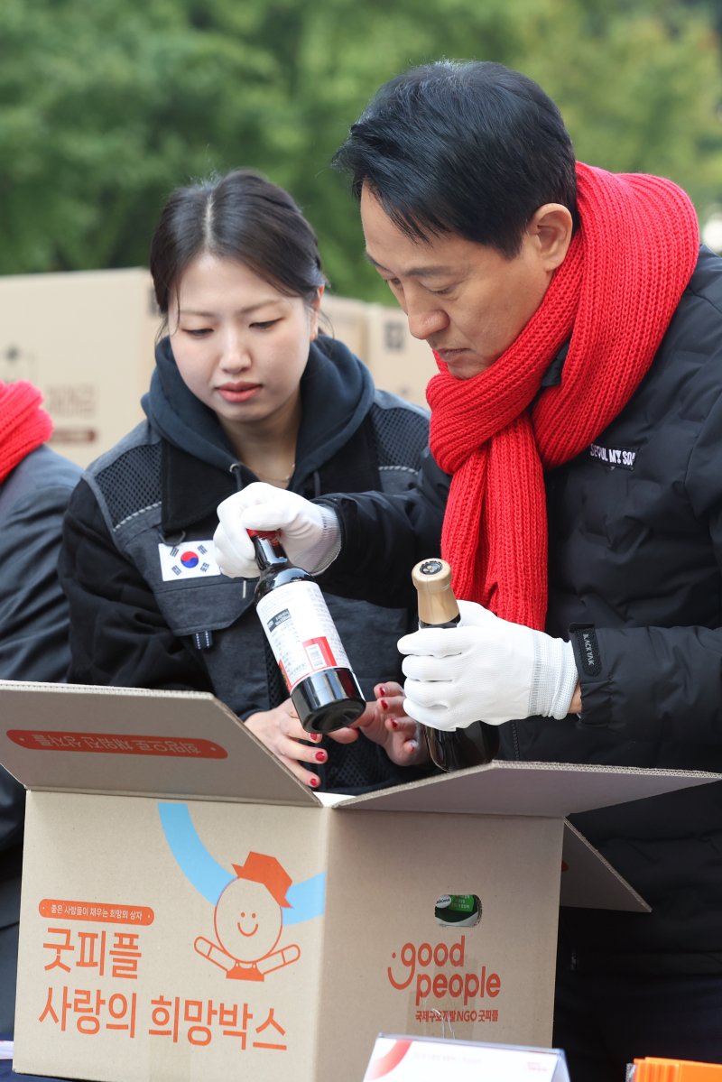 오세훈 서울시장이 4일 오전 서울 청계광장에서 열린 '2025 굿피플 사랑의 희망박스 박싱데이'에서 봉사자들과 함께 식료품 16종을 상자에 담고 있다. 2025.11.4/뉴스1 ⓒ News1 황기선 기자