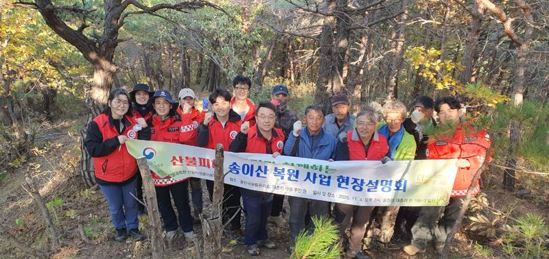 국립산림과학원이 지난 4일 경북 울진군 울진읍 대흥리 한 임야에서 진행한 '산불피해지 송이산 복원 시범사업 설명회'에서 주민 등 참석자들이 기념촬영을 하고 있다.