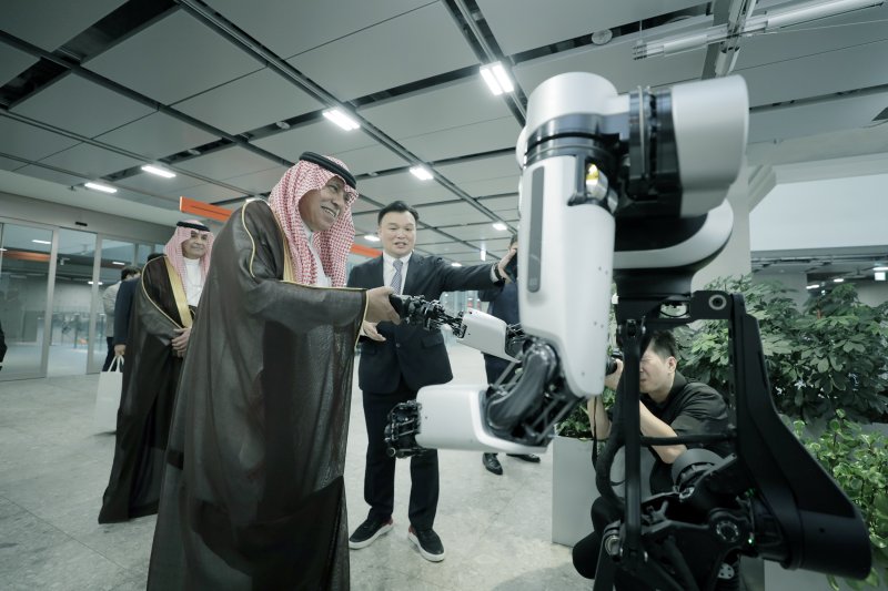 [서울=뉴시스]네이버는 사우디아라비아의 상업, 무역, 투자 등을 관할하는 상무부의 마지드 알 카사비 장관 일행이 29일 '테크 컨버전스 빌딩' 네이버 1784를 방문했다고 30일 밝혔다. 사진은 마지드 알 카사비 장관이 로봇팔 앰비덱스를 체험하는 모습. 2024.07.30. (사진=네이버 제공)