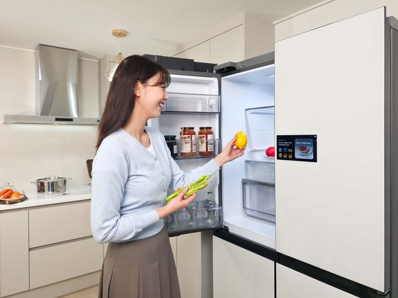 삼성전자 모델이 냉장고에 들어가고 나오는 식재료를 인식해 자동으로 푸드 리스트를 생성하는 'AI 비전 인사이드'를 체험하고 있다. 삼성전자 제공