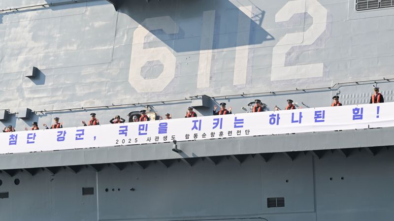 해군 대형수송함 마라도함(LPH)에 편승한 2025년 합동순항훈련전단 소속 해ㆍ육ㆍ공군ㆍ국군간호사관학교 2학년 사관생도들이 11월 5일 오전 진해 군항을 출항하며 손을 흔들고 있다. 해군 제공