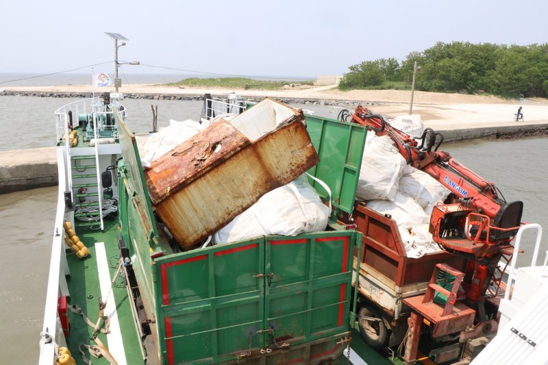 [서천=뉴시스] 서천군 장항읍 유부도에서 수거된 해양쓰레기들을 담은 트럭이 배에 실려 있는 모습. *재판매 및 DB 금지