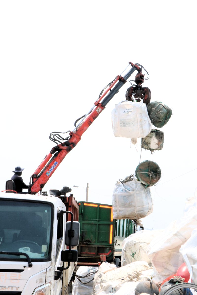 [서천=뉴시스] 서천군 유부도에서 작업자가 모아진 해양쓰레기들을 배로 운반하기 앞서 트럭에 싣고 있다. *재판매 및 DB 금지