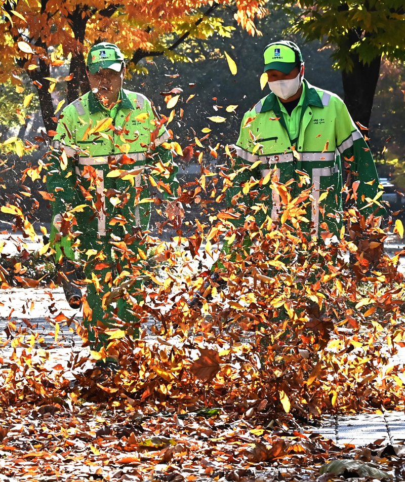 [수원=뉴시스] 김종택 기자 = 절기상 입동을 이틀 앞둔 5일 경기 수원시 팔달구 인계동 가로수길에서 환경관리원들이 전동 송풍기를 이용해 수북히 쌓인 낙엽을 청소하고 있다. 2025.11.05. jtk@newsis.com