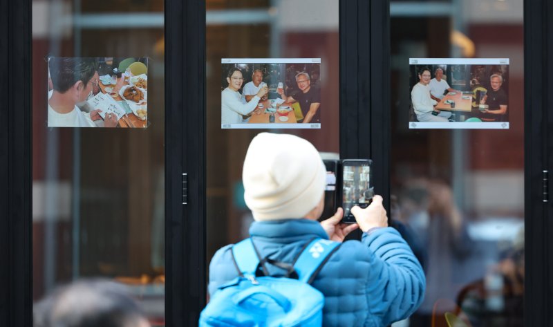 [서울=뉴시스] 황준선 기자 = 5일 젠슨 황 엔비디아 최고경영자와 이재용 삼성전자 회장, 정의선 현대차그룹 회장이 '치맥 회동'을 가졌던 서울 강남구 깐부치킨 삼성점을 찾은 시민들이 매장 외벽에 게시된 회동 당시 사진을 촬영하고 있다. 2025.11.05. hwang@newsis.com