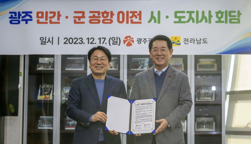 [나주=뉴시스] 이영주 기자 = 강기정 광주시장(왼쪽)과 김영록 전남도지사가 17일 오후 전남 나주 한국농수산식품유통공사 회의실에서 광주 군·민간 공항 이전 시·도지사 회담을 마친 뒤 합의문을 들어보이고 있다. 2023.12.17. leeyj2578@newsis.com