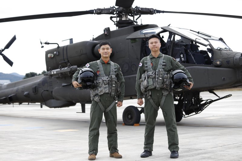 육군은 6일 2025년 육군항공 사격대회 시상식을 개최한다고 밝혔다. 사진은 2025 육군항공 사격대회 '탑 헬리건(Top Heligun)'으로 선발된 이대식(왼쪽)·조명환 준위가 아파치 헬기(AH-64E) 앞에서 포즈를 취하고 있다. 육군 제공