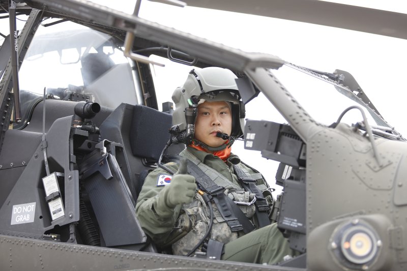 육군은 올해의 '탑 헬리건(TOP Heligun)'에 901항공대대 아파치 가디언(AH-64E) 조종사 이대식·조명환 준위가 선발돼 대통령상을 수상했다고 6일 밝혔다. 육군항공 사격대회 '탑 헬리건'으로 선발된 조명환 준위가 아파치 헬기(AH-64E)에서 포즈를 취하고 있다. 육군 제공