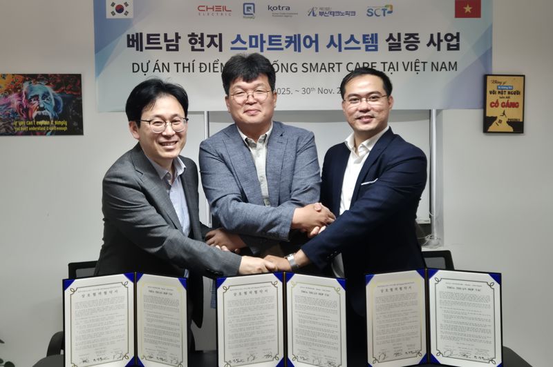 제일일렉트릭과 부산테크노파크 등이 공동 개발한 ‘스마트케어 시스템’의 베트남 현지 진출을 위한 HomeQ사와의 업무협약식에서 세 기관 관계자들이 함께 손을 맞잡고 기념촬영하고 있다. 부산테크노파크 제공