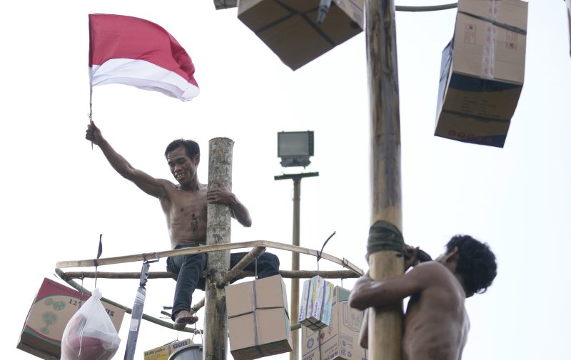 [자카르타=AP/메이저 바카라사이트 장난감] 제77주년 메이저 바카라사이트 장난감 독립기념일인 17일(현지시간) 자카르타의 안촐 해변에서 열린 기념행사 중 '기름 장대 오르기 경주'에 참가한 한 참가자가 꼭대기에 올라가 인도네시아 국기를 흔들고 있다. 미끄러운 장대 꼭대기에는 각종 상품이 매달려 있어 꼭대기에 오른 참가자는 상품을 가질 수 있다. 인도네시아는 1945년 8월 17일 네덜란드로부터 독립했다. 2022.08.17.
