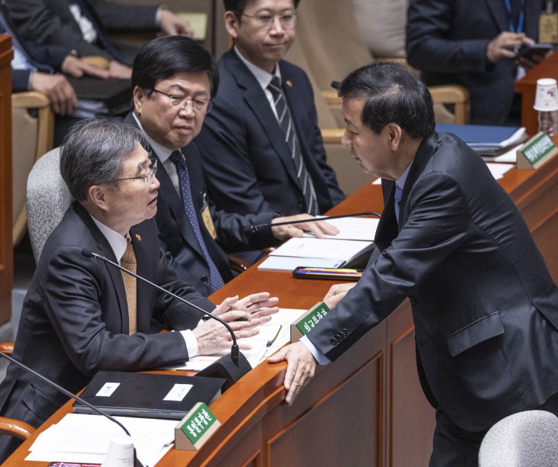 조현 외교부 장관(왼쪽)이 지난 6일 국회 예산결산특별위원회 회의장에서 열린 예결위 전체회의에 참석해 구윤철 경제부총리 겸 기획재정부 장관과 대화하고 있다. 연합뉴스