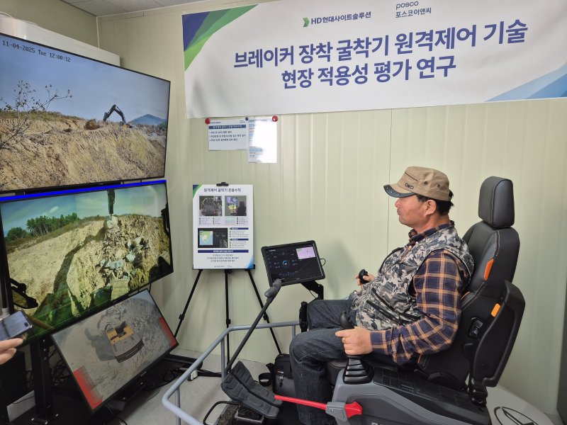 지난 4일 전남 여수 화태-백야 도로건설 현장 사무소에서 굴착기 운전 기능사가 원격으로 굴착기를 제어하고 있다.