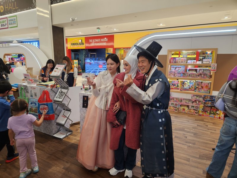 [뉴저지=뉴시스] 지난 7일(현지시간) 미국 뉴저지주 아메리칸드림몰에서 열린 '2025 뉴욕 한류박람회' B2C(기업-소비자 간 거래) 판촉전에 참가한 아트박스 관계자들이 한복을 입고 관람객들과 기념사진을 찍고 있다. 2025.11.09 photo@newsis.com *재판매 및 DB 금지