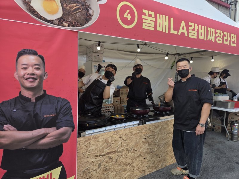 [구미=뉴시스] 변해정 기자 = 경북 구미역 일대에서 열린 '2025 구미라면축제'에서 '꿀배LA갈비짜장라면'을 선보인 윤쉐프의 고기집 윤수민 대표와 직원들이 밀려드는 주문에도 웃음을 잃지 않고 메뉴를 만들고 있다. 이 업체가 구미라면축제에 참여한 것은 이번이 세 번째다. 2025.11.09. hjpyun@newsis.com