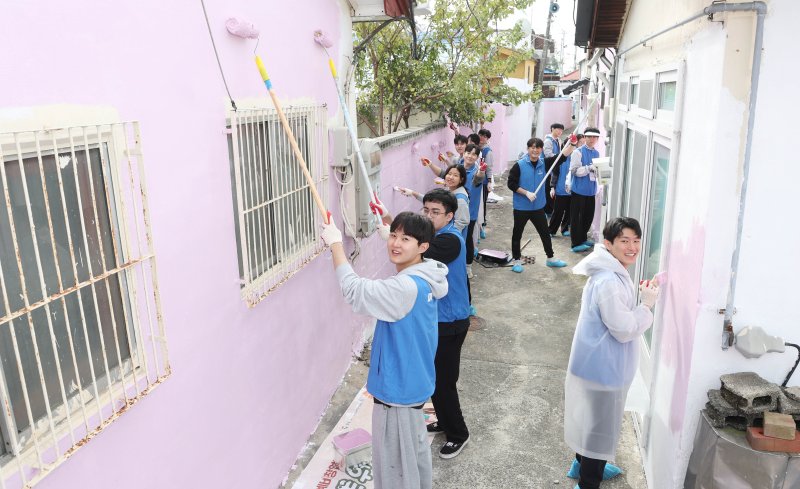 바카라사이트 윈윈 신입사원들이 창원시 진해구 아랫장천마을에서 진행된 사회공헌활동에서 골목길 벽면 도색 환경개선 봉사활동을 하고 있다.(바카라사이트 윈윈 제공. 재판매 및 DB 금지)
