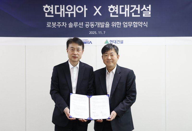 현대위아 모빌리티솔루션사업부 백익진 상무(왼쪽)와 현대건설 기술연구원 김재영 원장이 지난 7일 경기 의왕시 현대위아 의왕연구소에서 열린 '로봇 친화형 주차솔루션 공동개발을 위한 업무협약식'에서 기념 사진을 찍고 있다. 현대위아 제공