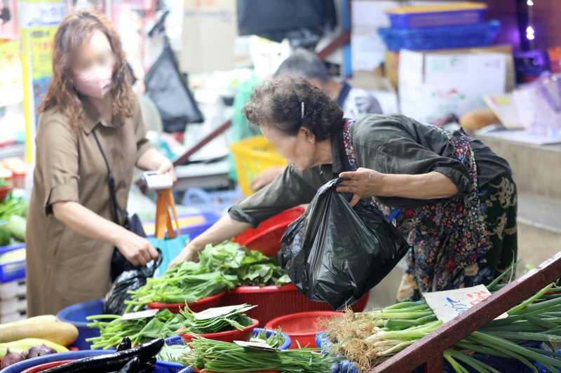 경기 수원 팔달구 못골종합시장의 한 채소 가게에서 시민들이 채소를 구매하고 있다. 2022.7.18/뉴스1 ⓒ News1 김영운 기자