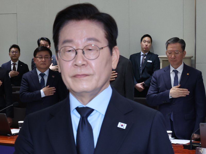 이재명 대통령과 정성호 법무부 장관(오른쪽)이 11일 용산 대통령실에서 열린 국무회의에서 국기에 경례하고 있다. 연합뉴스