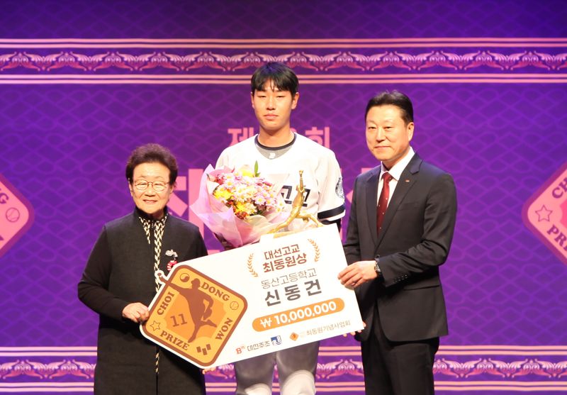 대선주조 최성욱 본부장(오른쪽)이 최동원 선수 모친인 김정자 여사(왼쪽)와 함께 제8회 대선 고교 최동원상 수상자 동산고 신동건과 기념 촬영을 하고 있다. 대선주조 제공