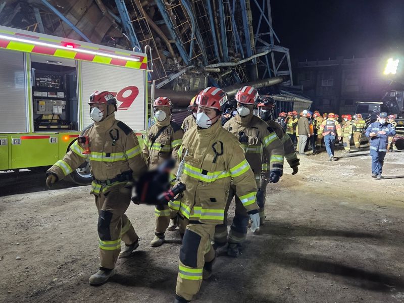 울산화력발전 붕괴 현장에서 11일 오후 10시 14분께 매몰자 7명 중 4번째 사망자의 시신이 수습됐다. 구조대원들이 수습한 시신을 구급차로 옮기고 있다. 소방청 제공