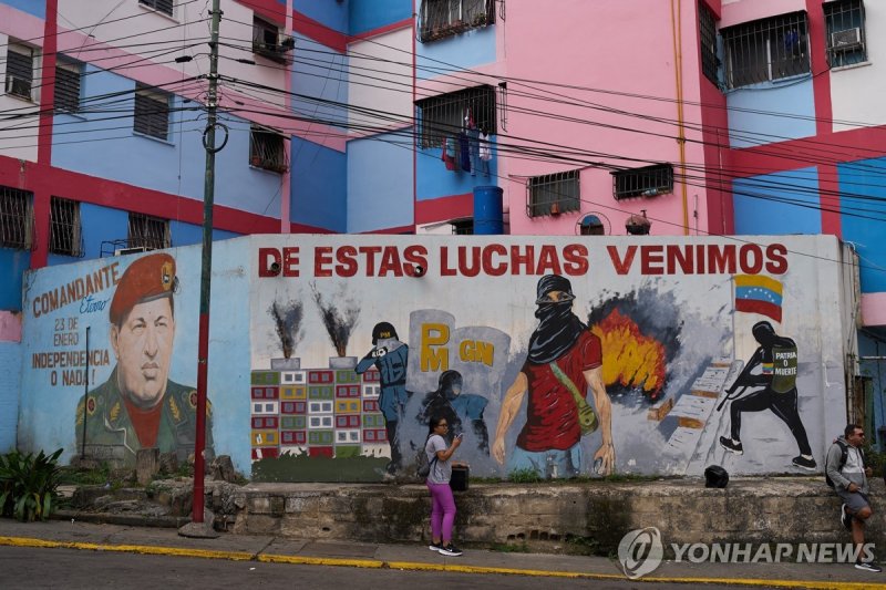 11일(현지시간) 베네수엘라 좌파 지도자 우고 차베스 벽화(왼쪽)와 투쟁 의지를 고취하는 글귀 (출처=연합뉴스)