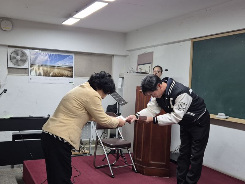 2026학년도 대학수학능력시험을 하루 앞둔 12일 서울 마포구 일성여자중고등학교에서 올해 최고령 응시자 서해숙씨가 수험표를 받고 있다. 사진=장유하 기자