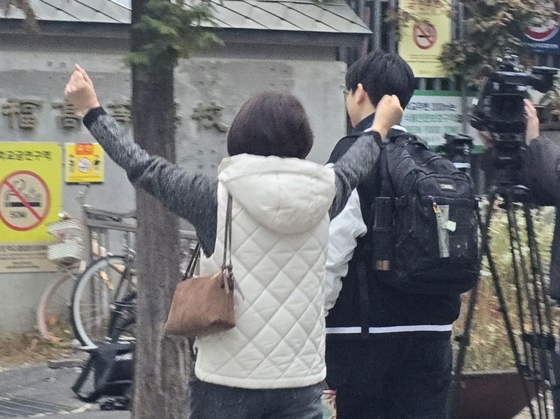 2026학년도 대학수학능력시험(수능)일인 13일 오전 서울 종로구 경복고등학교 앞에서 어머니 박영란씨(56)가 아들을 응원하고 있다. 사진=서지윤 기자