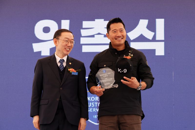 14일 인천 영종도 하늘체육공원에서 열린 관세청장배 탐지견 경진대회에서 명예 탐지견핸들러에 위촉된 강형욱 훈련사(오른쪽)가 이명구 관세청장과 기념촬영을 하고 있다.사진=박범준 기자