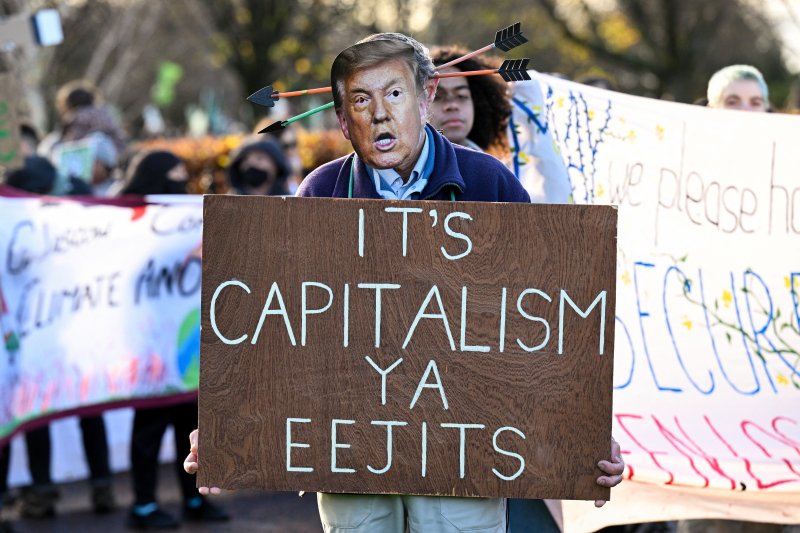 지난 15일(현지시간) 영국 글래스고에서 한 시위대가 제30차 유엔 기후변화협약 당사국 총회(COP30)에 불참한 미국을 비난하며 도널드 트럼프 미국 대통령의 사진을 들고 있다.로이터연합뉴스