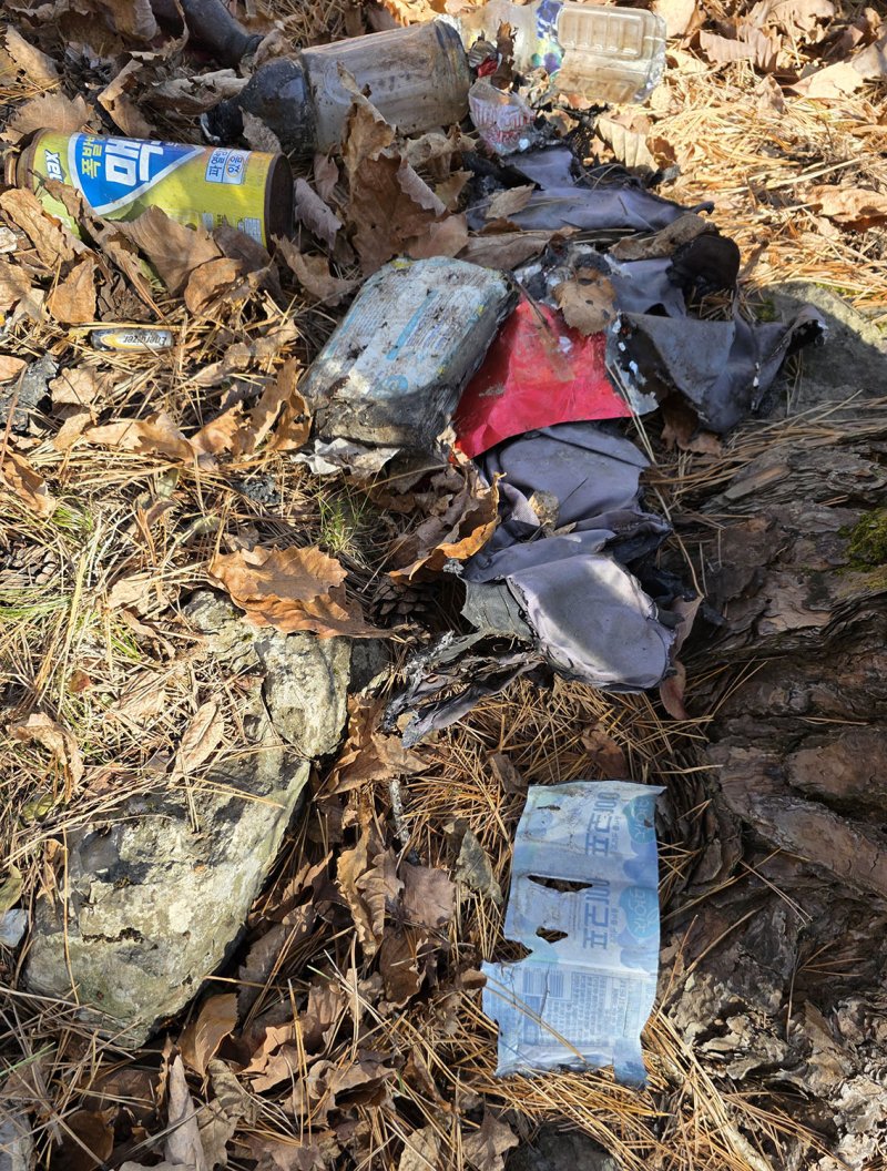 지난 15일 태백시 문곡소도동 함백산 기슭 '목없는 시신'이 발견된 현장에서 수습된 생수병과 콜라병, 부탄가스통, 불에 태운 옷가지 등 모습.(사진=뉴시스) *재판매 및 DB 금지