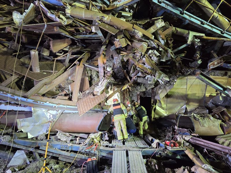 지난 6일 붕괴된 울산화력발전 보일러 타워 5호기 매몰 현장에서 구조대원들이 수색 작업을 위해 철구조물 사이에서 통로를 확보하고 있다. 울산소방본부 제공