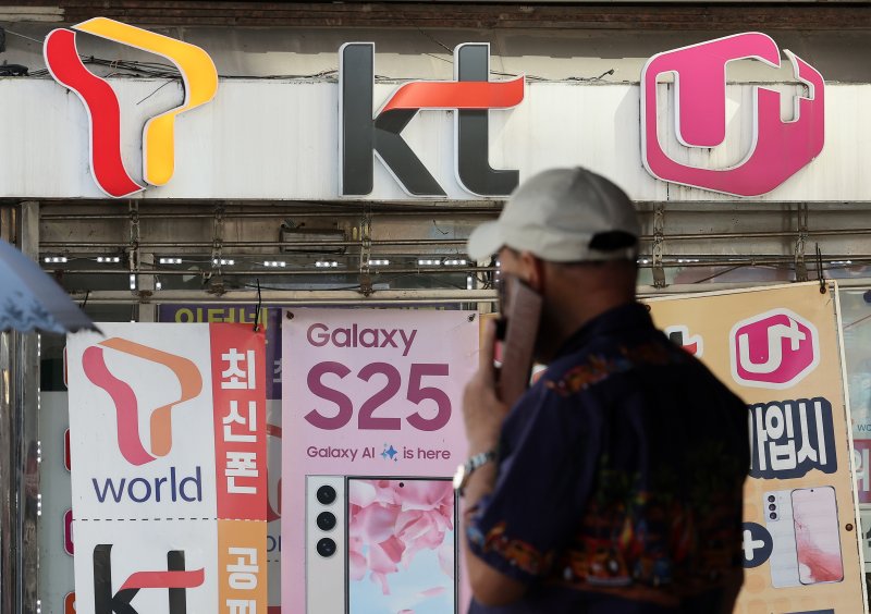 이동통신 3사와 일부 이커머스 사이트 등의 해킹사태가 일어난 후 정부가 이통 3사와 플랫폼 등에 대한 보안심사 기준을 높이는 방안을 추진 중이다. 한 시민이 통화를 하며 이통 3사 대리점 앞을 지나고 있다. 연합뉴스